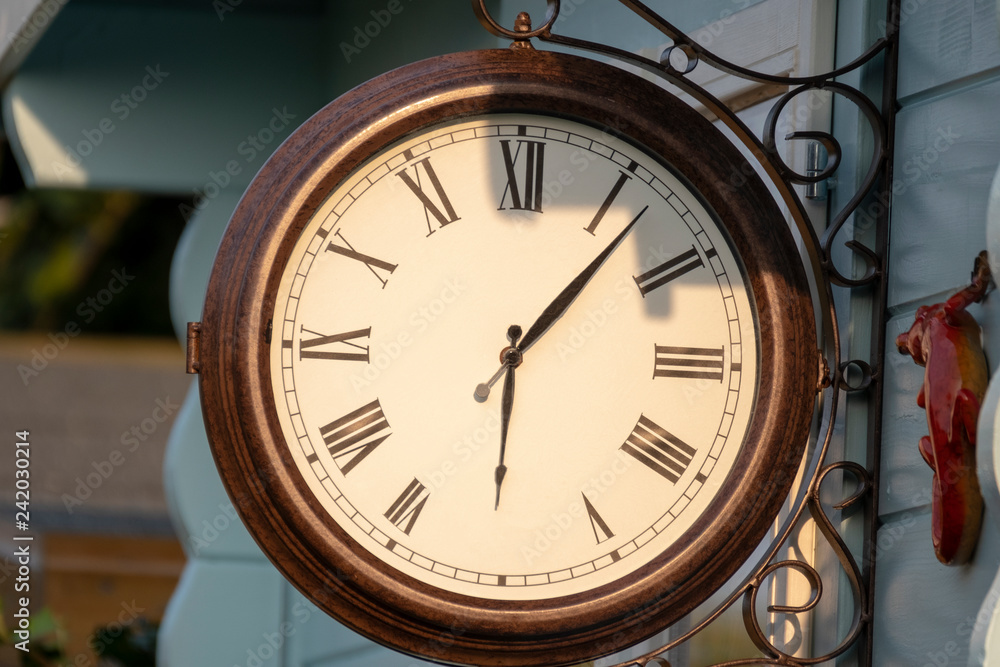 Garden clock hanging on wooden outside wall of summer house. Garden clock hanging on wooden outside wall of summer house.