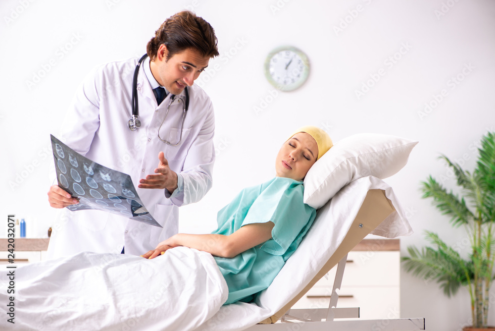 Fototapeta premium Young handsome doctor visiting female oncology patient 