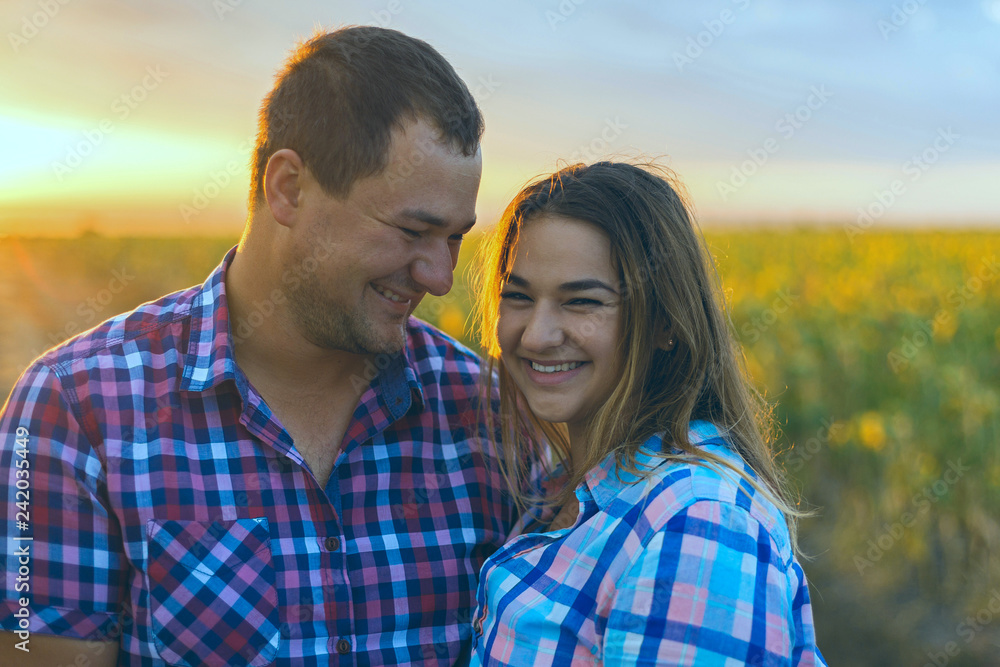Young romantic couple in a field of sunflowers, pregnant girl in sunflowers	