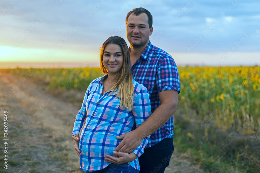 Young romantic couple in a field of sunflowers, pregnant girl in sunflowers Young romantic couple in a field of sunflowers, pregnant girl in sunflowers