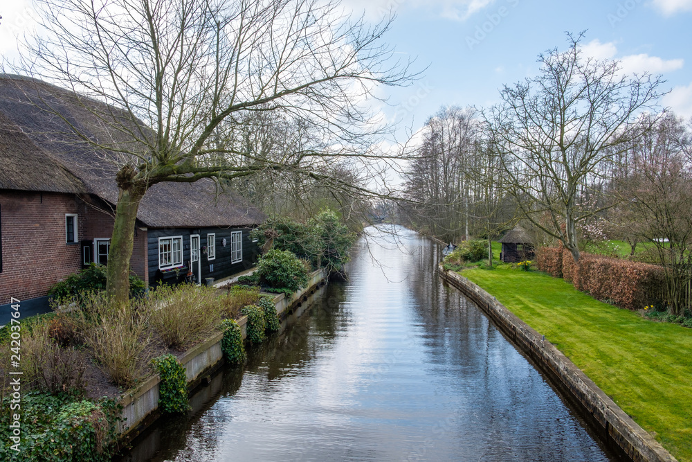 Early spring view on Giethoorn, Netherlands, a traditional Dutch village with canals and rustic thatched roof farm houses. Early spring view on Giethoorn, Netherlands, a traditional Dutch village with canals and rustic thatched roof farm houses.