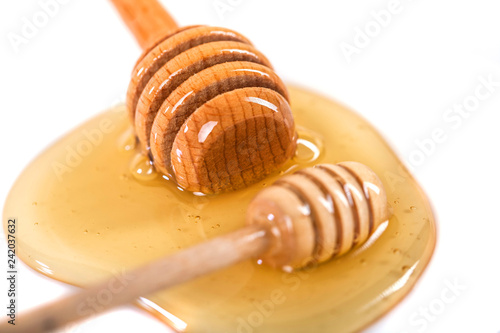Honey with wooden dipper isolated on white background