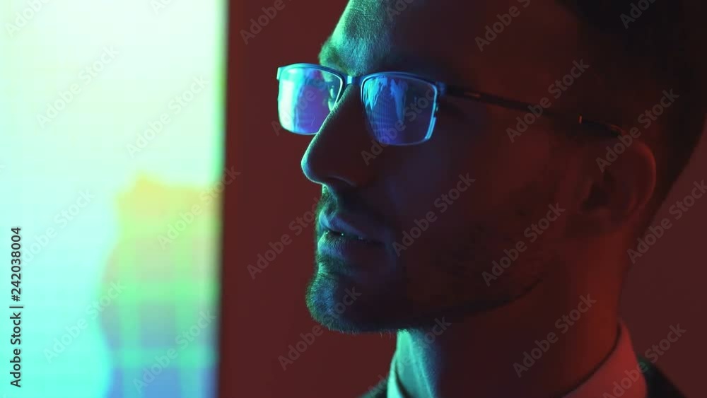 The businessman in glasses looking to the display The businessman in glasses looking to the display