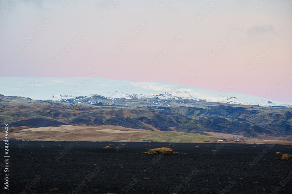 Icelandic Sunset over mountain black stones in foreground Icelandic Sunset over mountain black stones in foreground
