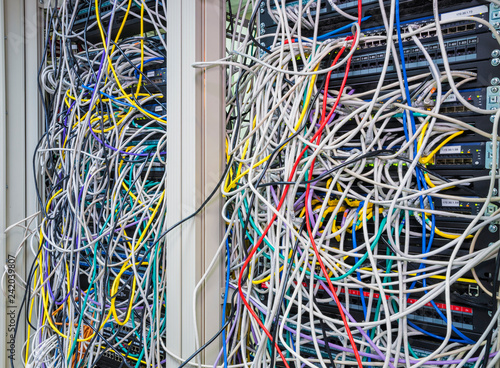 Switchboard panel with chaotic mess  cables connections, Chaos In Server Room, The tangled network cable
