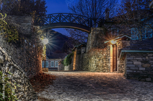 Traditional stone-built houses in the village of Nymfaio. There is a small bridge in the background. Night photo. HDR photo