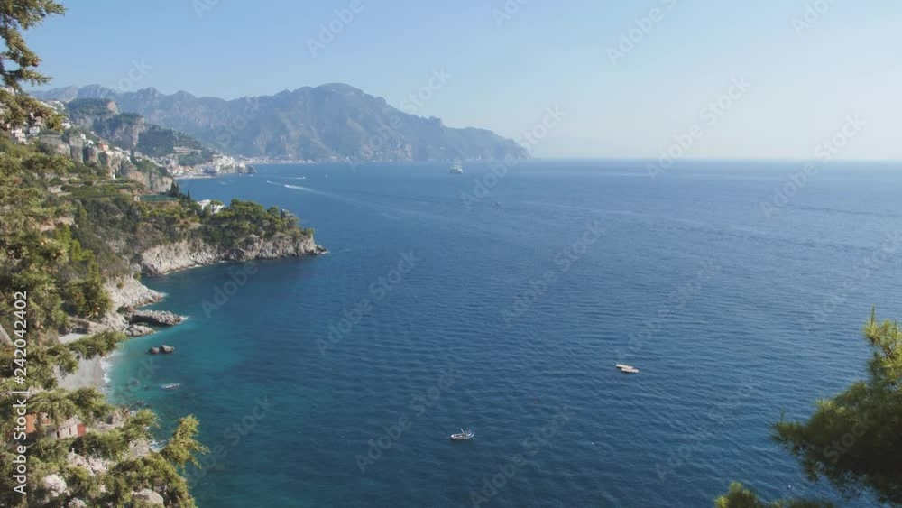 Mountains over blue sea. Town houses on hillside. Morning over Amalfi coast, Italy Mountains over blue sea. Town houses on hillside. Morning over Amalfi coast, Italy