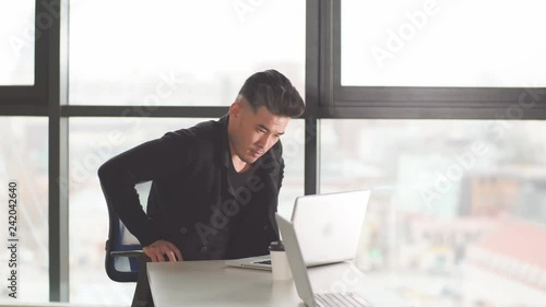 Portrait of Asian male lowyer in formal at his desk in the office and looking at his personal computer photo