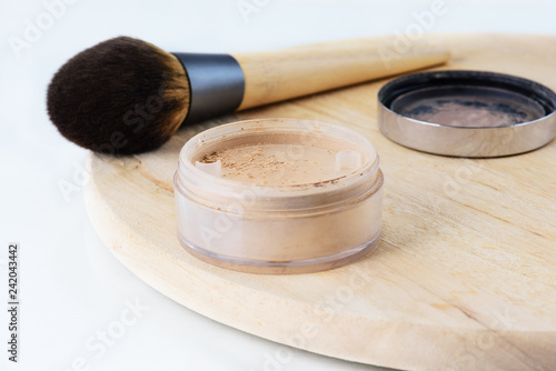 Loose powder with a brush on the table. Face makeup.