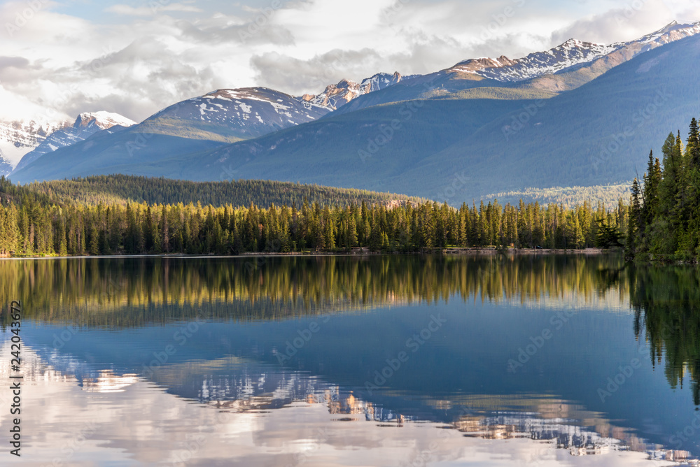 Mountain and Lake lined with colourful chairs with reflection in Jasper Canada