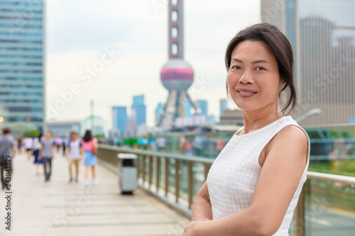 Free Download Asian middle age woman model smiling happy in Shanghai city street. Chinese mature businesswoman China professional. - GFXLoad
