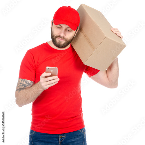 Delivery man in red uniform holding box package with smartphone isolated on white background