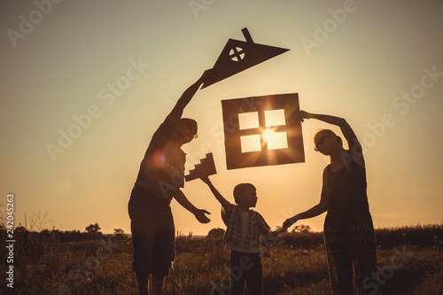 Happy family standing on the field at the sunset time. photo