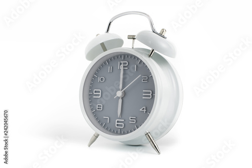 Twin bells analogue alarm clock with gray clock face shows six o’clock, 6 AM PM; concept on white background