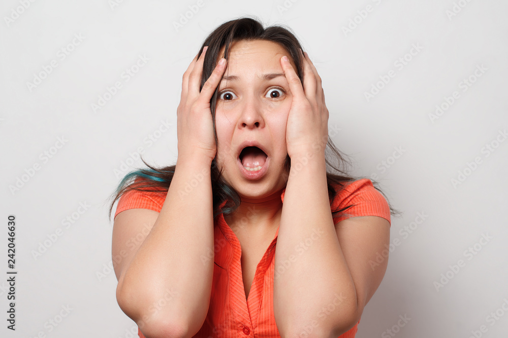 pretty girl shocked grabbed his head in a red dress, studio, isolated pretty girl shocked grabbed his head in a red dress, studio, isolated