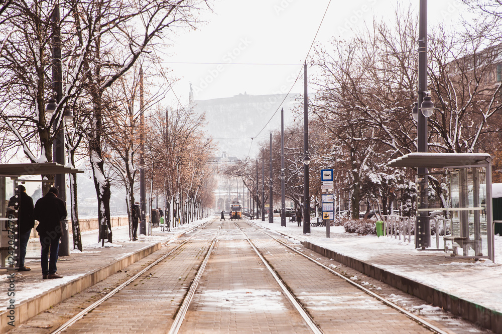 Fototapeta premium Yellow tram and rails on the embankment from Buda side in winter in Budapest, Hungary