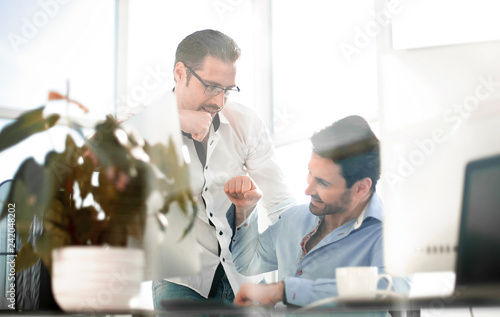 business background.Two smiling male colleagues giving fist bumps