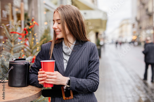 Woman Drink Her Hot Coffee While Sitting In Cafe. Portrait Of Stylish Smiling Woman In Spring Clothes Drinking Hot Coffee. Female Spring-Autumn Style. - Image