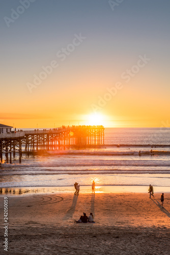 People doing activities at the beach near the pier with beautiful sunset. Pacific Beach in San Diego, California