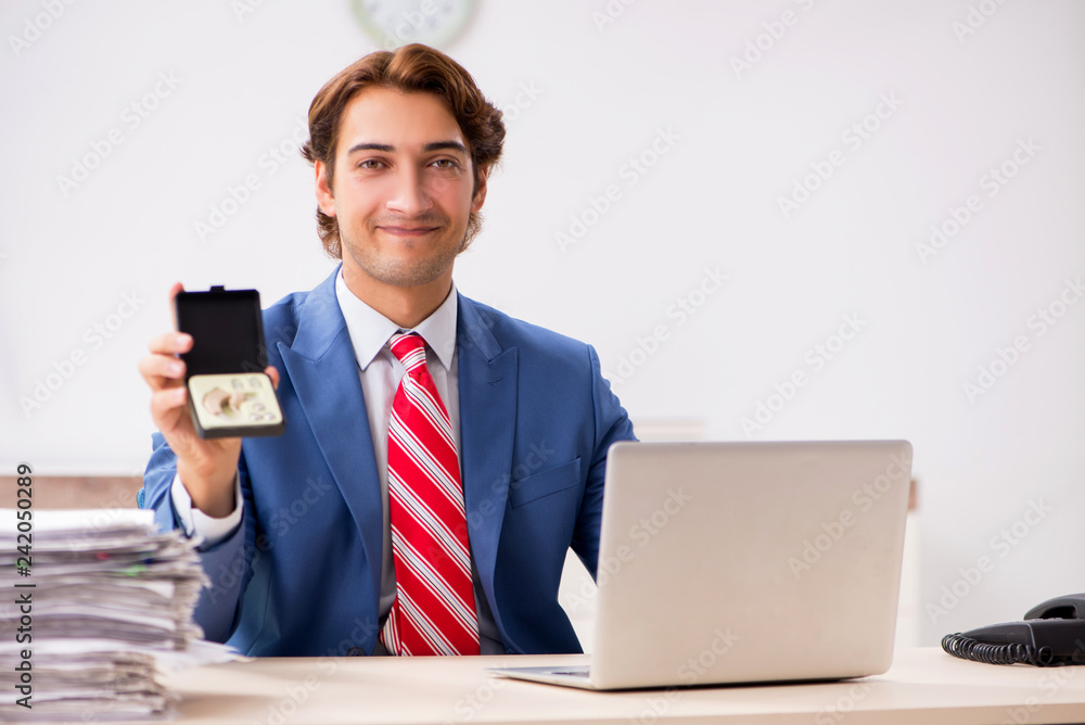 Deaf employee using hearing aid in office Deaf employee using hearing aid in office