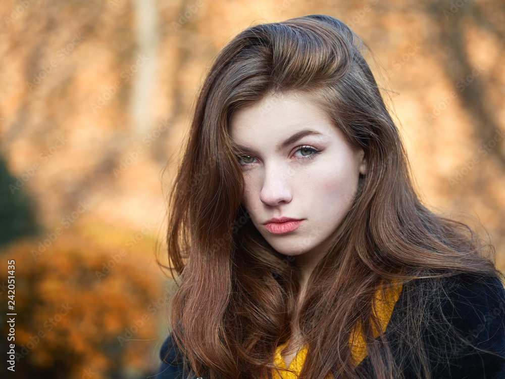 Fabulous redhead woman with long hair in yellow sweater black leather jacket on blurred autumn background. Fabulous redhead woman with long hair in yellow sweater black leather jacket on blurred autumn background.