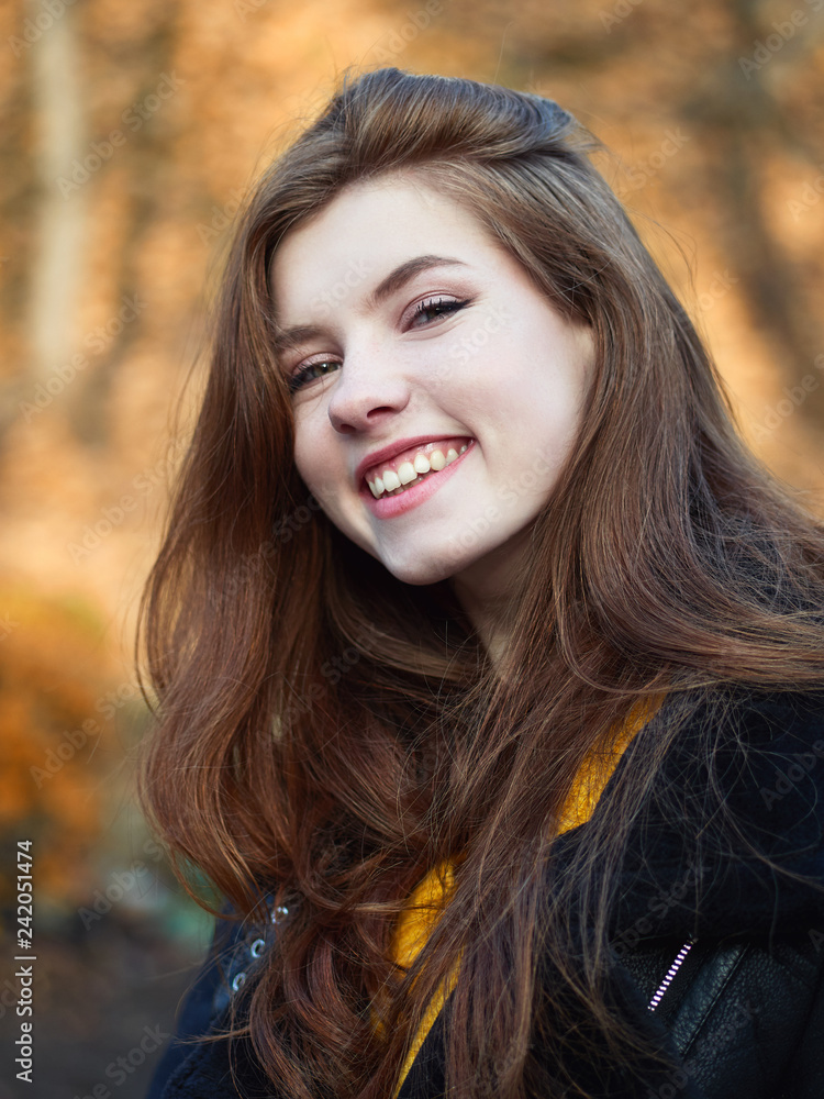 Fabulous redhead woman with long hair in yellow sweater black leather jacket on blurred autumn background. Fabulous redhead woman with long hair in yellow sweater black leather jacket on blurred autumn background.