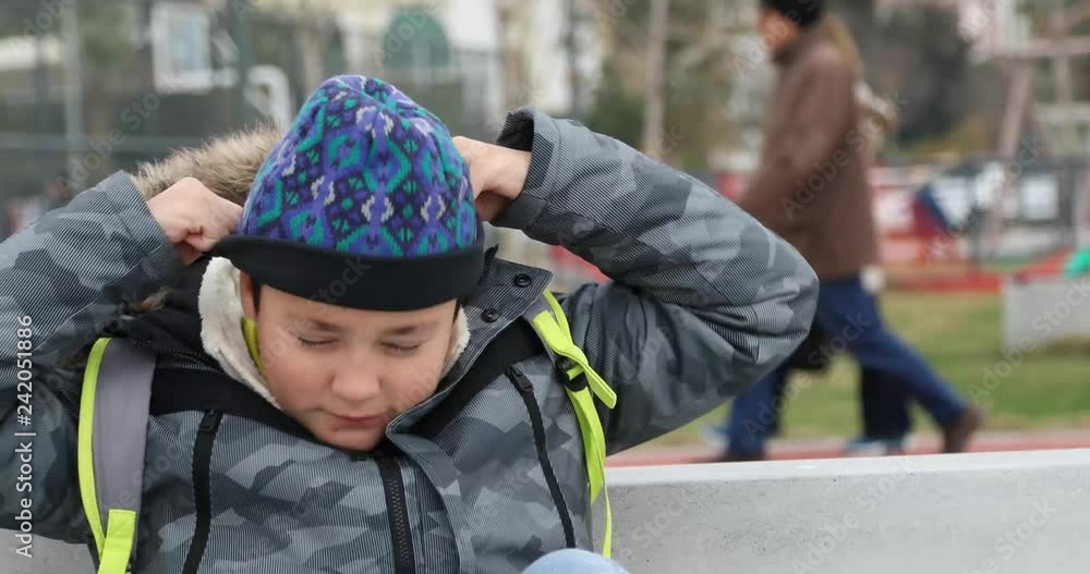 Preteen boy with flue sitting on a park bench in winter park 2 Preteen boy with flue sitting on a park bench in winter park 2
