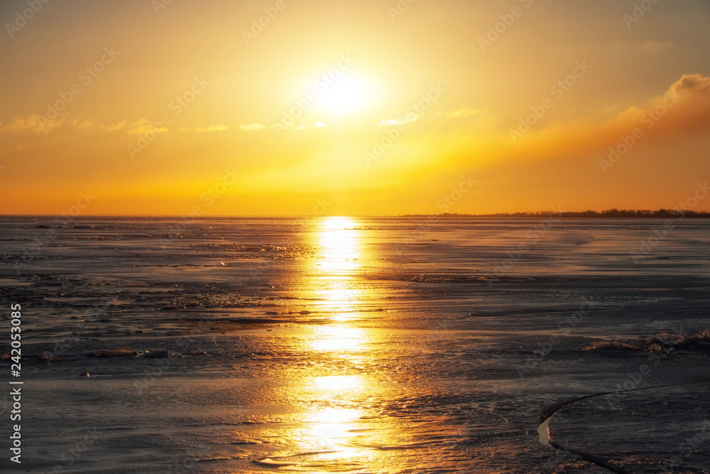 Obraz premium Zima krajobraz z zamarzniętym jeziorem i zmierzchu ognistym niebem. Skład natury.