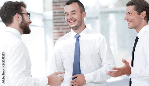 employees are talking ,standing in the office.