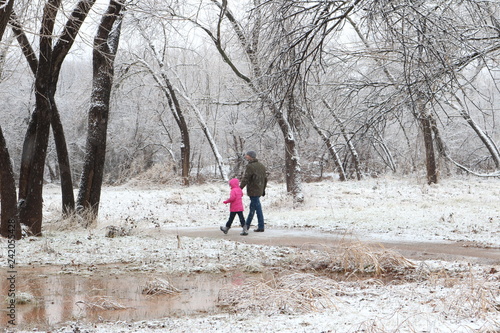 Father and young daughter hiking in the snow