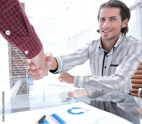 colleagues shaking hands over Desk