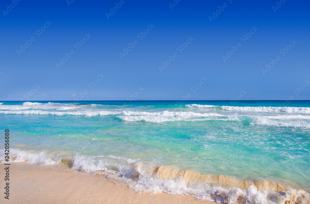 Ocean waves, wet sand and blue sky