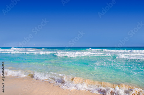 Ocean waves, wet sand and blue sky