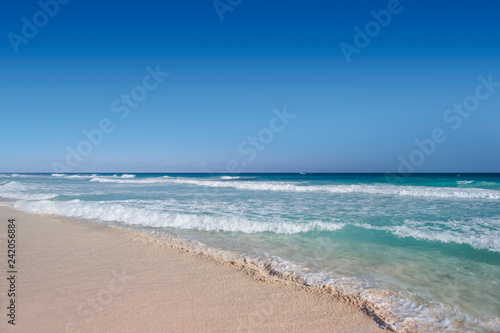 Ocean waves  wet sand and blue sky