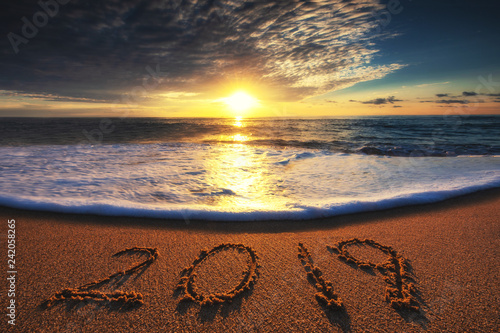 Happy New Year 2019 concept, lettering on the beach. Sea sunrise