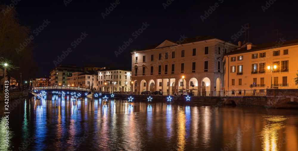4 January 2019 Treviso (north Italy): Treviso by night during Christmas Time. the University Bridge and the light stars reflect on the river Sile. University Building on the right.