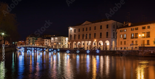 4 January 2019 Treviso (north Italy): Treviso by night during Christmas Time. the University Bridge and the light stars reflect on the river Sile. University Building on the right.