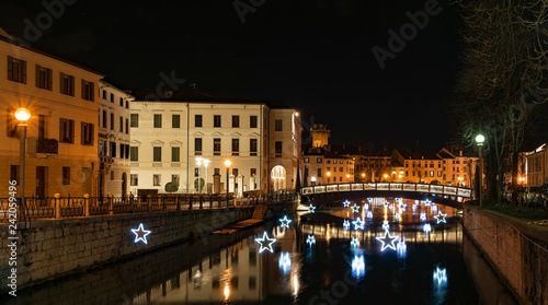 4 January 2019 Treviso (north Italy): Treviso by night during Christmas Time. the University Bridge and the light stars reflect on the river Sile. University Building on the left.
