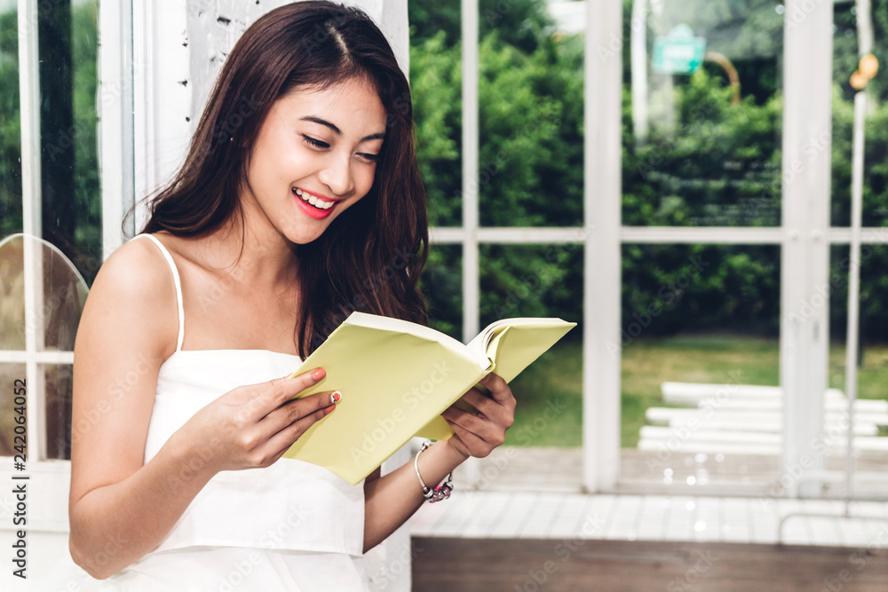 Beautiful young woman relaxing reading a book in cafe Beautiful young woman relaxing reading a book in cafe