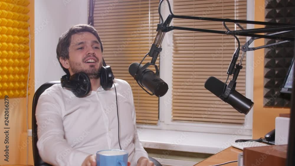 Young man with headphones talking on mic. Online radio and podcasting concept. Young man with headphones talking on mic. Online radio and podcasting concept.