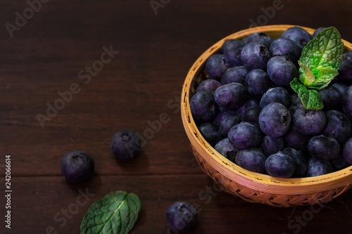 Fresh Blueberries in a basket on dark moody background, selective focus