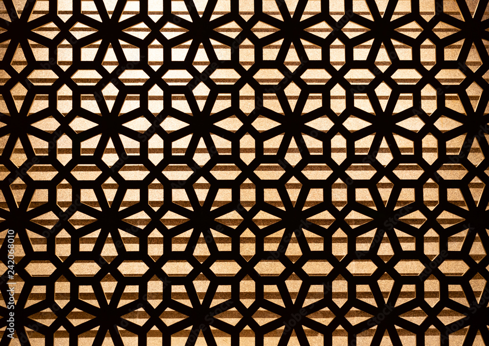 Wooden carve pattern decoration on the wall with lighting in background. Wooden carve pattern decoration on the wall with lighting in background.