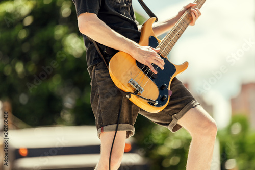 Close-up of bassist playing at an outdoor show