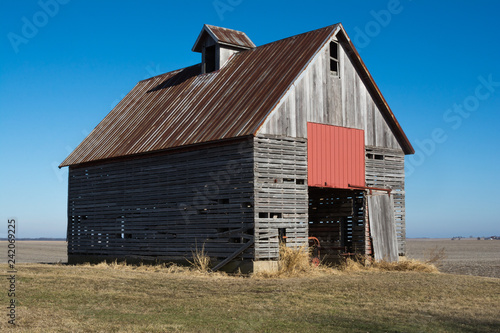 Old wooden barn in the rural open farmland. Illinois, USA