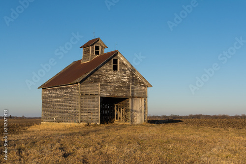 Old weathered wooden barn in open field on a Winter afternoon.  LaSalle County, Illinois, USA © EJRodriquez
