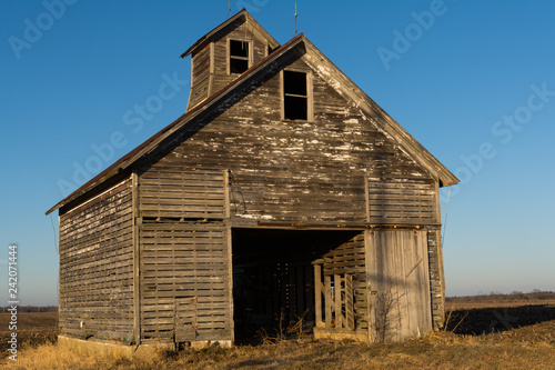 Old weathered wooden barn in open field on a Winter afternoon. LaSalle County, Illinois, USA