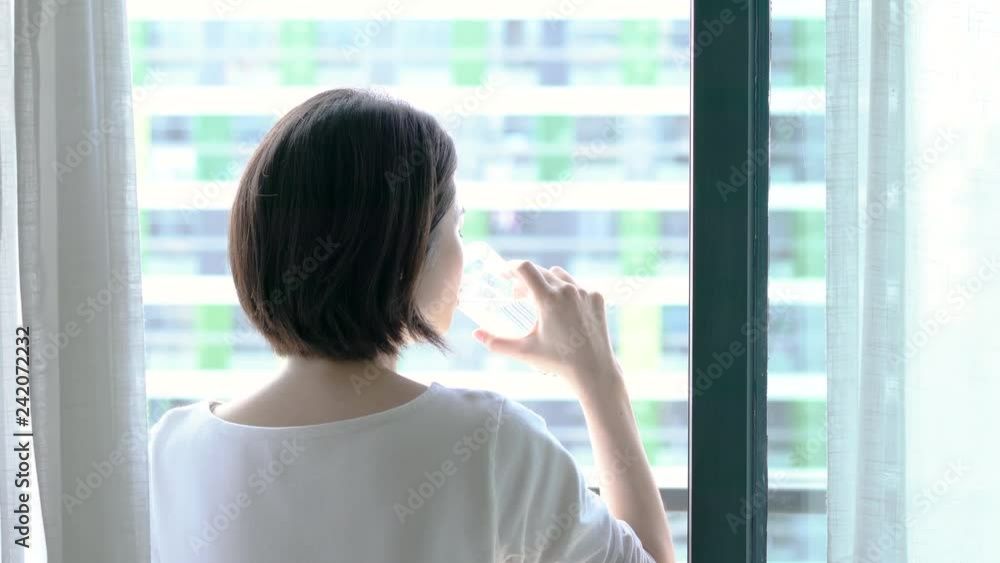  female drinking water on balcony