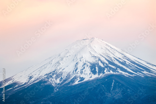 Fuji Mountain in sunset time on soft orange sky background  blue Fuji Mt. snow on top and focus Fuji mountain close up to the top beautiful mountain in Japan. this mountain is symbol of Japan.