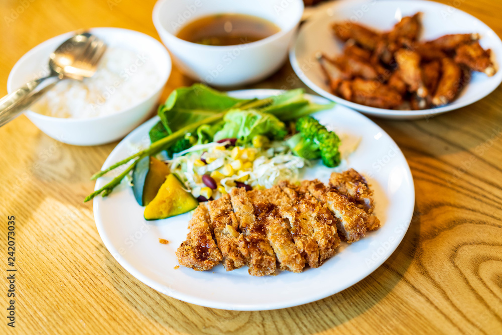 Japanese pork Tonkatsu homemade with fresh vegetable serve on table. Japanese pork Tonkatsu homemade with fresh vegetable serve on table.