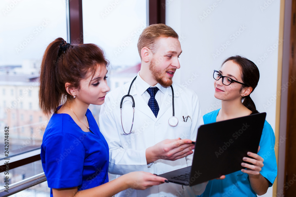 healthcare. A group of student medical students communicates in front of a laptop. Discussion of the diagnosis healthcare. A group of student medical students communicates in front of a laptop. Discussion of the diagnosis